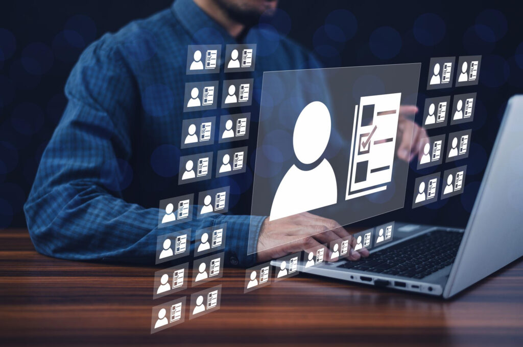 Photo of a person sitting at a laptop with a superimposed holographic image representing personal data.